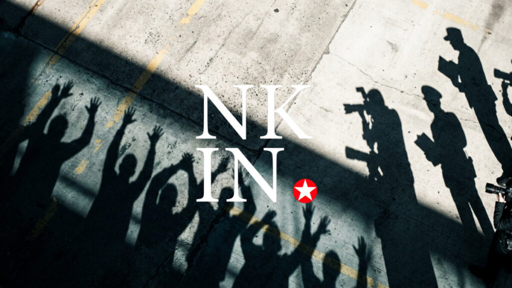 4 | nk insider shadows of people including photographers cast on a concrete surface around large white text reading'NK IN' with a red star logo nearby.