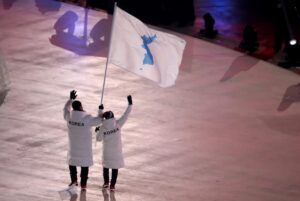 North Korean ice hockey player Hwang Chung-gum and South Korean bobsledder Won Yun-jong jointly carry the Korean Unification Flag at the 2018 PyeongChang Winter Olympics opening ceremony, symbolizing unity. Sean M. Haffey/Getty Images